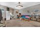 Comfortable and functional living room with a ceiling fan, futon, desk, and ample storage at 12932 W Cassia Trl, Peoria, AZ 85383