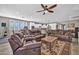 Comfortable living room featuring a ceiling fan, plantation shutters, and opening to kitchen at 12932 W Cassia Trl, Peoria, AZ 85383