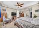 Comfortable main bedroom featuring a ceiling fan, a TV, and an ensuite bathroom with a walk-in closet at 12932 W Cassia Trl, Peoria, AZ 85383
