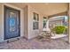 Inviting front porch featuring decorative iron door, tiled flooring and a cozy seating area at 12932 W Cassia Trl, Peoria, AZ 85383