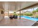 Spacious covered back patio with a pool and manicured landscaping at 13216 W Desert Ln, Surprise, AZ 85374