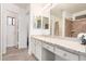 Primary bathroom with granite countertops, double sinks, and walk-in shower is light and bright at 13216 W Desert Ln, Surprise, AZ 85374
