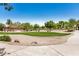 Landscaped common area featuring green grass and mature trees, enhancing the community's appeal at 13216 W Desert Ln, Surprise, AZ 85374