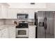Updated kitchen with white cabinets, stainless steel appliances, and granite countertops at 13216 W Desert Ln, Surprise, AZ 85374