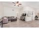 Living room with an open layout, tile floors, a ceiling fan, and a view of the kitchen at 13216 W Desert Ln, Surprise, AZ 85374