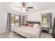 Relaxing primary bedroom featuring large windows, wood-look tile flooring, and neutral colors at 13216 W Desert Ln, Surprise, AZ 85374