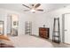 Bright primary bedroom is adorned with wood-look tile floors, a ceiling fan, and access to an ensuite at 13216 W Desert Ln, Surprise, AZ 85374