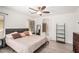 Spacious primary bedroom featuring a ceiling fan, wood-look tile flooring, and ensuite bathroom at 13216 W Desert Ln, Surprise, AZ 85374