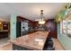 Kitchen with stainless steel appliances, tiled backsplash, long island and seating, wood cabinets, and pendant lights at 1326 W Joan De Arc Ave, Phoenix, AZ 85029
