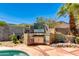 Well-equipped outdoor kitchen with grill, mosaic backsplash, and ample counter space at 1326 W Joan De Arc Ave, Phoenix, AZ 85029