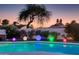 Serene backyard with a pool, hot tub, and colorful lighting, perfect for evening relaxation and outdoor entertainment at 14012 N 57Th Pl, Scottsdale, AZ 85254