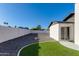 A landscaped backyard with artificial turf, a rock garden, and a painted brick perimeter wall at 14012 N 57Th Pl, Scottsdale, AZ 85254