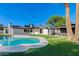 Lush backyard featuring a pool, palm trees, and covered patio, creating a private oasis for relaxation and entertainment at 14012 N 57Th Pl, Scottsdale, AZ 85254