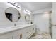 Elegant bathroom with double vanity, modern lighting, and a luxurious marble-tiled shower at 14012 N 57Th Pl, Scottsdale, AZ 85254