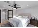 Bright bedroom with modern lighting, neutral tones, and sliding barn door to the bathroom at 14012 N 57Th Pl, Scottsdale, AZ 85254