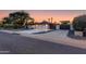 Well-maintained home exterior with a spacious driveway, mature trees, and a modern fence at 14012 N 57Th Pl, Scottsdale, AZ 85254