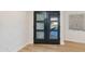 Stylish interior view of the glass paneled front door with wood floors and modern wall decor at 14012 N 57Th Pl, Scottsdale, AZ 85254