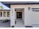 Inviting front entrance with modern architectural details, a black framed door, and manicured landscaping at 14012 N 57Th Pl, Scottsdale, AZ 85254