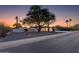 Charming single-story home with a large tree in the front yard, desert landscaping, and a white exterior at 14012 N 57Th Pl, Scottsdale, AZ 85254