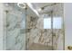 Luxurious glass shower with rainfall showerhead, marble tile surround, and built-in niche at 14012 N 57Th Pl, Scottsdale, AZ 85254