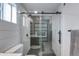 Glass-enclosed shower featuring black hardware, geometric patterned tiles, and a built-in shower niche at 14012 N 57Th Pl, Scottsdale, AZ 85254