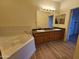 Primary bathroom with double sink vanity, large soaking tub, and tile accents at 14250 W Wigwam Blvd # 1723, Litchfield Park, AZ 85340