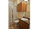 An efficiently designed bathroom with vinyl wood flooring, a shower, and wooden cabinets at 14250 W Wigwam Blvd # 1723, Litchfield Park, AZ 85340