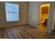 Cozy bedroom featuring wood-look floors, a bright window, and attached bathroom at 14250 W Wigwam Blvd # 1723, Litchfield Park, AZ 85340