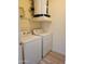 A convenient laundry room equipped with a washer, dryer, and storage shelves at 14250 W Wigwam Blvd # 1723, Litchfield Park, AZ 85340