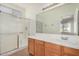 This bathroom features a large mirror over a vanity and a walk-in shower with glass doors at 1501 S 122Nd Ave, Avondale, AZ 85323