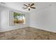 Bright bedroom with tile flooring, a ceiling fan, and bright windows to the outdoors at 1641 W Windsong Dr, Phoenix, AZ 85045