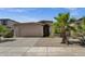 Charming home exterior featuring a two-car garage and low maintenance desert landscaping at 1641 W Windsong Dr, Phoenix, AZ 85045
