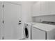 Convenient laundry room with modern washer and dryer, complemented by cabinetry for storage and a door for privacy at 1641 W Windsong Dr, Phoenix, AZ 85045