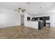 Bright living room with tile floors, ceiling fan, and a view into the kitchen with dark cabinetry at 1641 W Windsong Dr, Phoenix, AZ 85045