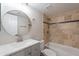 Bright bathroom with round mirror, quartz countertops, and a bathtub with tile surround at 16609 S 41St St, Phoenix, AZ 85048