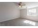 This bedroom offers carpet flooring, base molding, a ceiling fan, and a sunlit window at 16609 S 41St St, Phoenix, AZ 85048