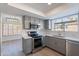Modern kitchen with stainless steel appliances, gray cabinets, and quartz countertops at 16609 S 41St St, Phoenix, AZ 85048