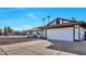 Side view of a single-story house showing a long driveway and a white garage door at 1720 W Highland St, Chandler, AZ 85224