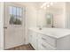 Well-lit bathroom featuring white cabinets and a view to the backyard at 1727 W 12Th Ave, Apache Junction, AZ 85120