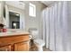 Bathroom featuring a toilet, vanity, sink, and a shower curtain with floral patterns at 17426 W Calavar Rd, Surprise, AZ 85388