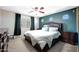 Bedroom with a ceiling fan, neutral carpet, a dark green wall and a large bed at 17426 W Calavar Rd, Surprise, AZ 85388