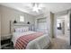 Bedroom with a white ceiling fan, gray walls, a large bed and an open closet at 17426 W Calavar Rd, Surprise, AZ 85388