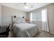 Cozy bedroom boasts soft carpet, a plush bed, and gentle light filtering through sheer white curtains at 17426 W Calavar Rd, Surprise, AZ 85388