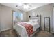 Comfortable bedroom features a cozy bed, soft window lighting, and a full-length mirror, perfect for relaxation at 17426 W Calavar Rd, Surprise, AZ 85388