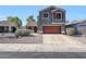Charming two-story home with a well-maintained yard and a red garage door at 17426 W Calavar Rd, Surprise, AZ 85388