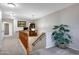 Upstairs hallway with wood railing, gray carpet, and a view of the downstairs from the landing at 17426 W Calavar Rd, Surprise, AZ 85388
