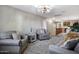 Cozy living area with neutral-toned seating, soft carpet, and an inviting chandelier above the staircase at 17426 W Calavar Rd, Surprise, AZ 85388