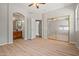 Empty bedroom with wood floors, closet with mirror doors, and an archway to a bathroom at 17805 W Arizona Dr, Surprise, AZ 85374
