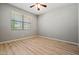 A clean and bright bedroom features wood-look floors and a window with blinds at 17805 W Arizona Dr, Surprise, AZ 85374
