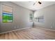 Bedroom with light gray walls, wood floors, and windows with views of green foliage at 17805 W Arizona Dr, Surprise, AZ 85374